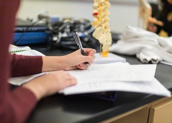 student taking notes in science classroom