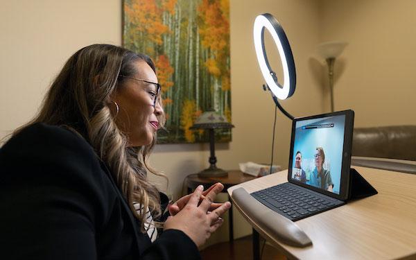 a therapist talks to teletherapy patients on a laptop at the Center for Counseling, Family and Play in Thornton